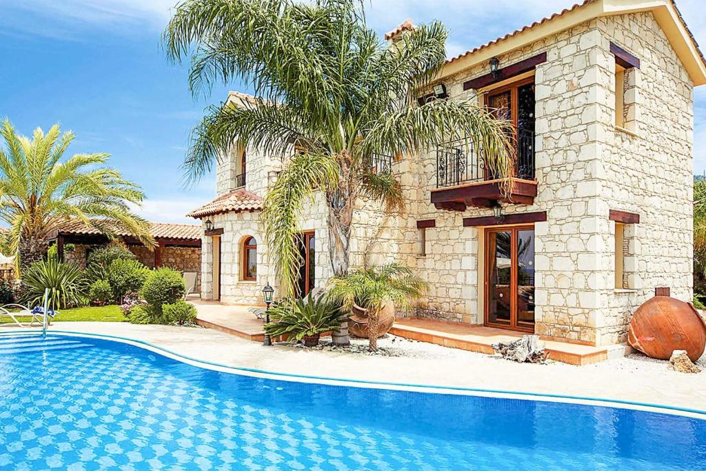 uma casa com piscina em frente a uma casa em Villa Stavroulla em Argaka