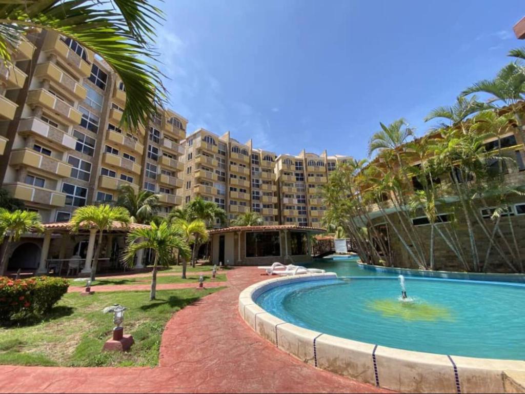 a resort with a swimming pool and a large building at Apartamento en La mejor zona de Pampatar. in Pampatar