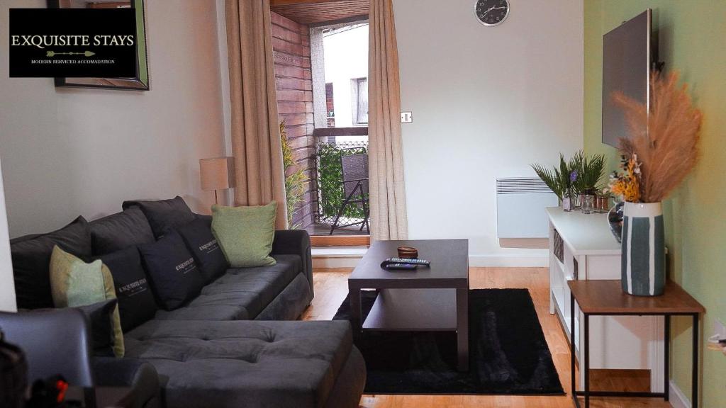 a living room with a couch and a table at Exquisite, 2 bed apartment with free parking! in Coventry
