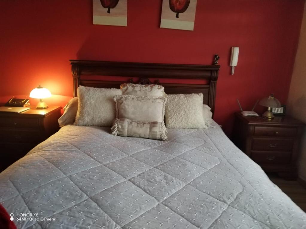 een slaapkamer met een groot bed met rode muren bij Quinta imperio del sol in Latacunga