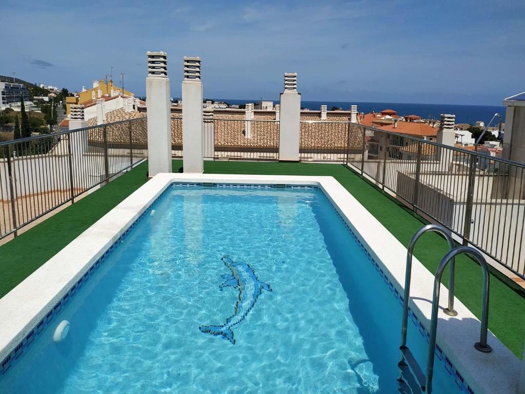a swimming pool with a shark in the water at Apartamentos Neptuno 3000 in Alcossebre