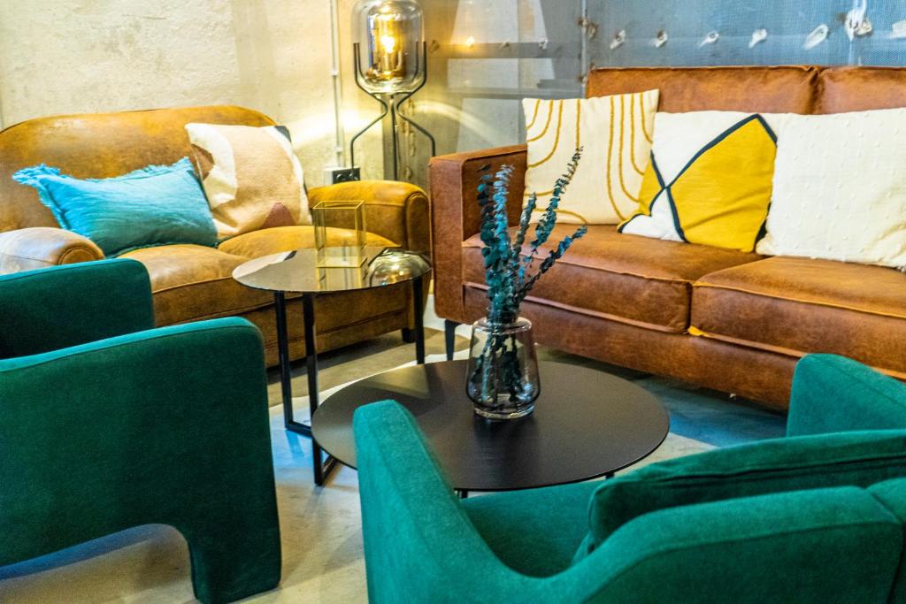 a living room with a couch and a table with chairs at Black Swan Hostel Granada in Granada