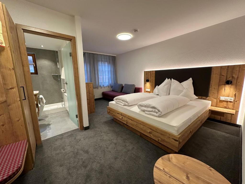 a bedroom with a large bed and a bathroom at Hotel Ochsen in Ammerbuch
