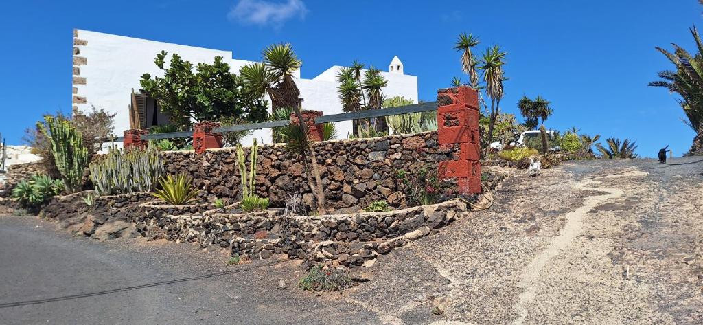 una pared de piedra frente a una casa en Casa Jardín de Tiagua, en Tiagua