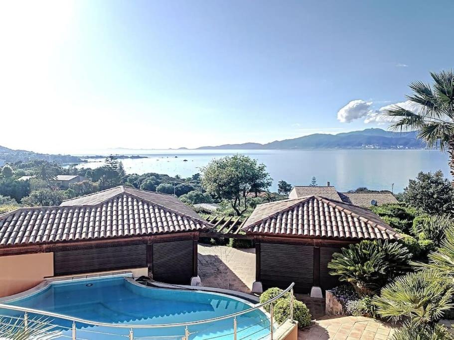 een huis met een zwembad en uitzicht op het water bij VILLA VUE MER in Pietrosella