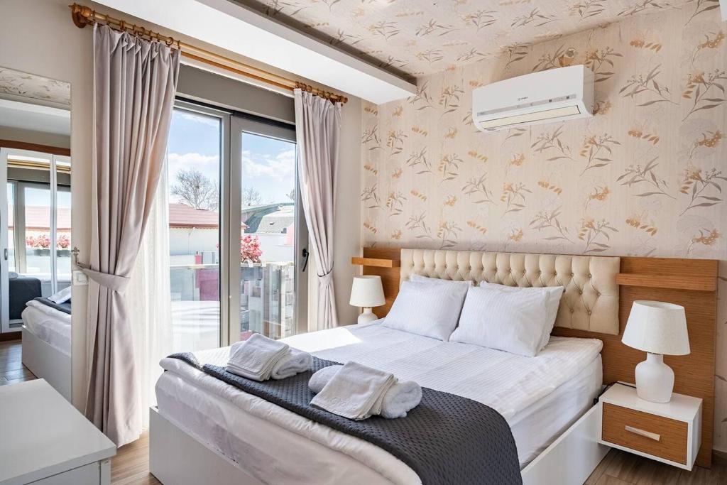 1 dormitorio con 1 cama con 2 toallas en Loi Suite en Antalya