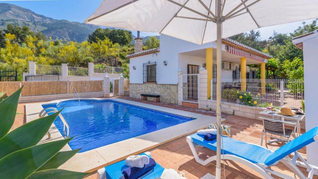 eine Villa mit einem Pool und einem Sonnenschirm in der Unterkunft Casa La Fajara 2 Canillas de Aceituno by Ruralidays in Canillas de Aceituno