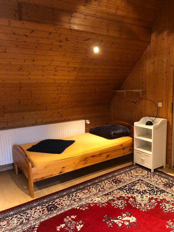 1 dormitorio con cama de madera en el ático en Wohnung in Wald- und Seenähe en Erkner