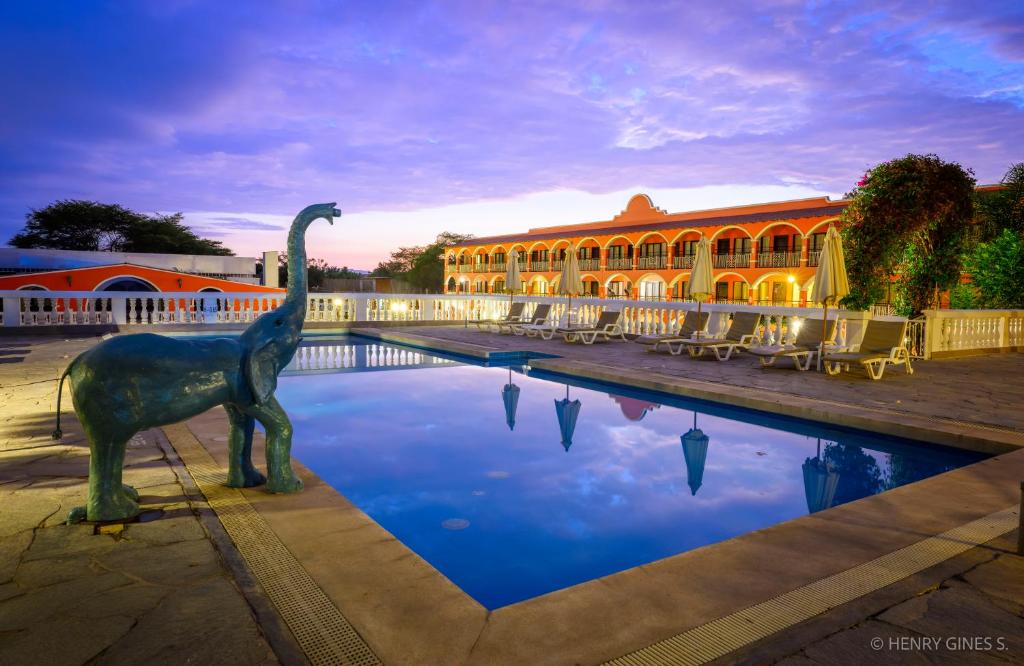 une statue d'un dinosaure devant un bâtiment dans l'établissement Hacienda San Juan Resort, à Ica