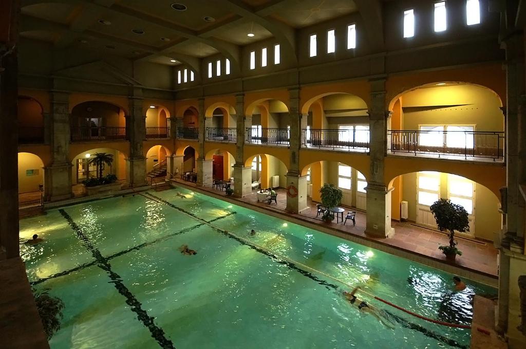 een binnenzwembad in een groot gebouw bij Relaxing Spacious Balcony Super Central Near Opera in Boedapest