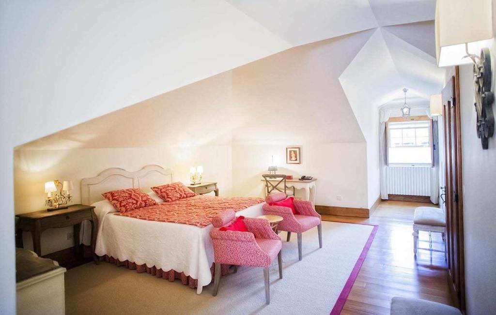 ein Schlafzimmer mit einem großen Bett mit rosa Kissen in der Unterkunft Casa da Cerca in Mondim da Beira