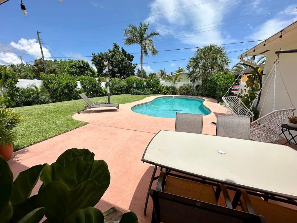 a swimming pool in a yard with a table and chairs at Good Vibes House with private pool in Dania Beach