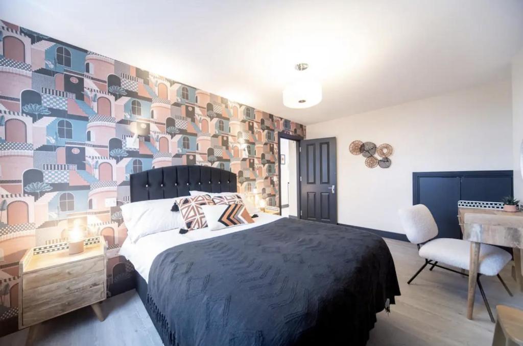 a bedroom with a large bed and a table and chair at Bright and Spacious - 2 Bed Flat w/ Jacuzzi in Crystal Palace