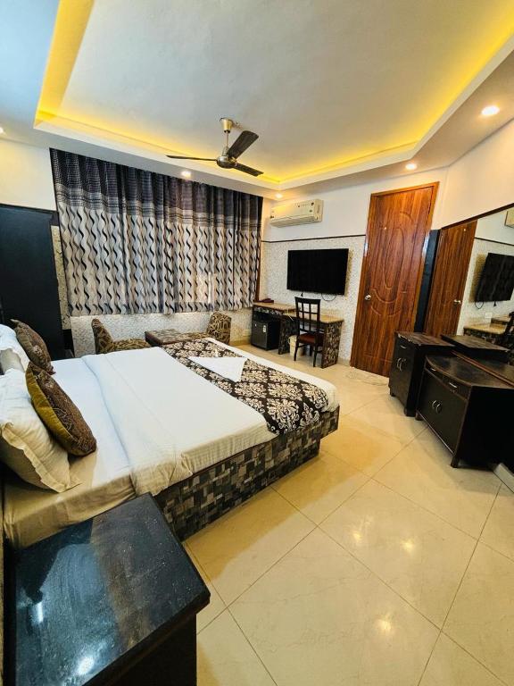 a bedroom with a bed and a desk and a television at Hotel Satwah Home Stay in New Delhi