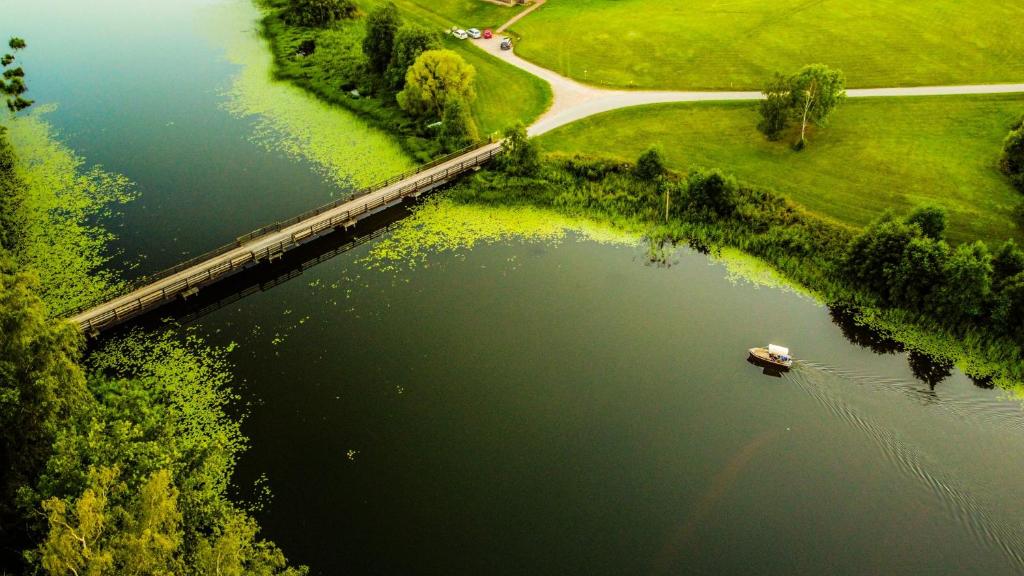 uma vista aérea de um lago com um barco nele em Kempingas "Obuolių sala" em Molėtai