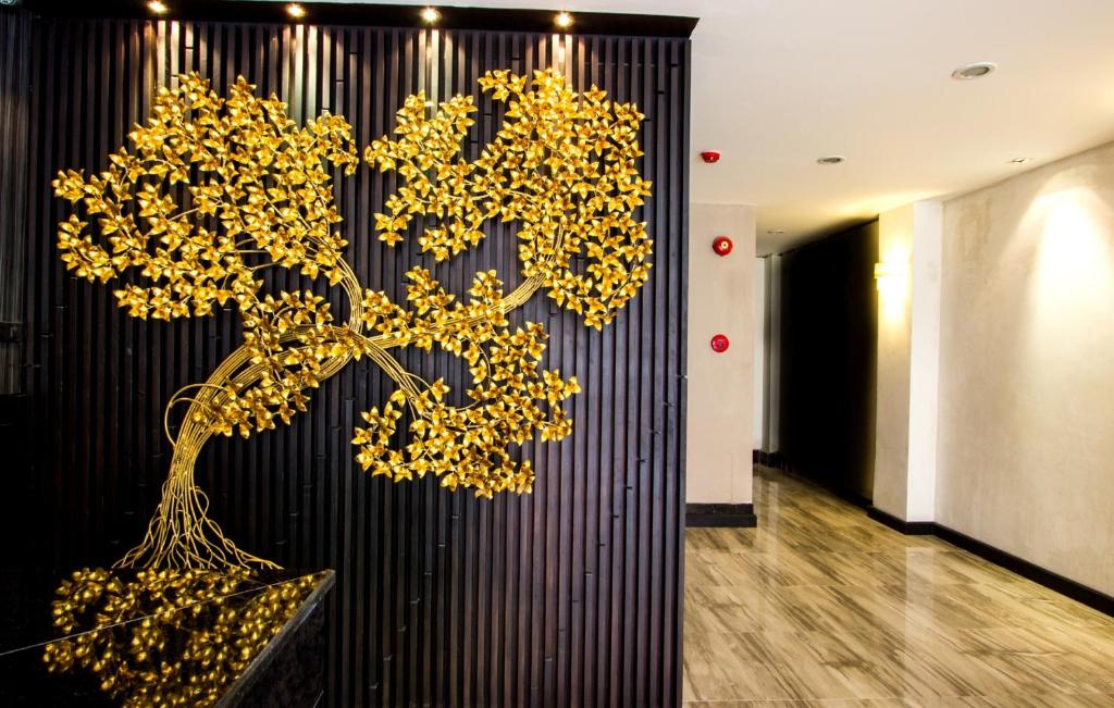 a room with a wall with a tree on it at Sakura Sky Residence in Bangkok