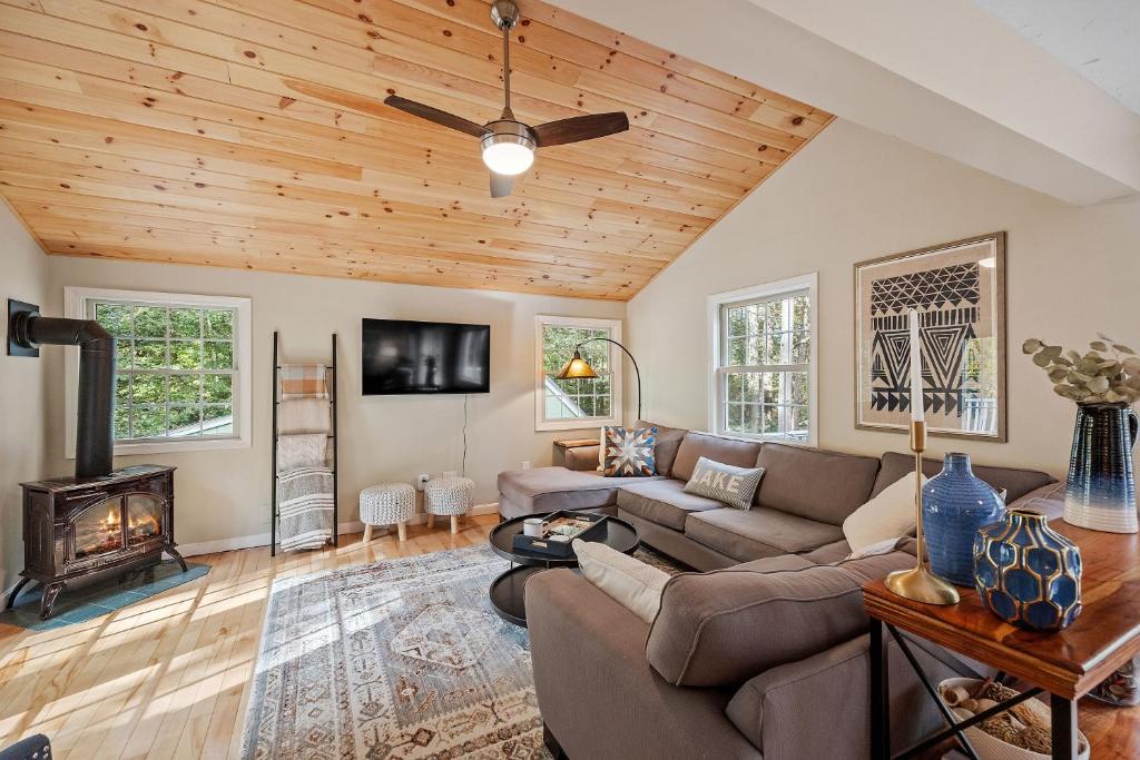 a living room with a couch and a fireplace at Leisure Chalet close to Lake, Gunstock, Bank of New Hampshire Pavilion. in Gilford