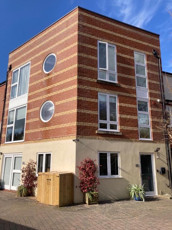 a brick building with white windows on a street at Streamside Apartments in Yeovil