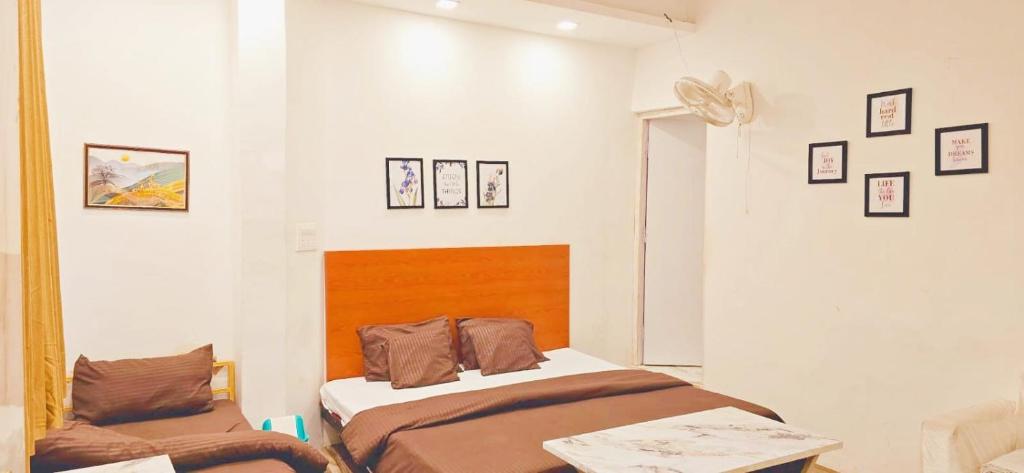 a bedroom with two beds and pictures on the wall at KP Residency in Lucknow