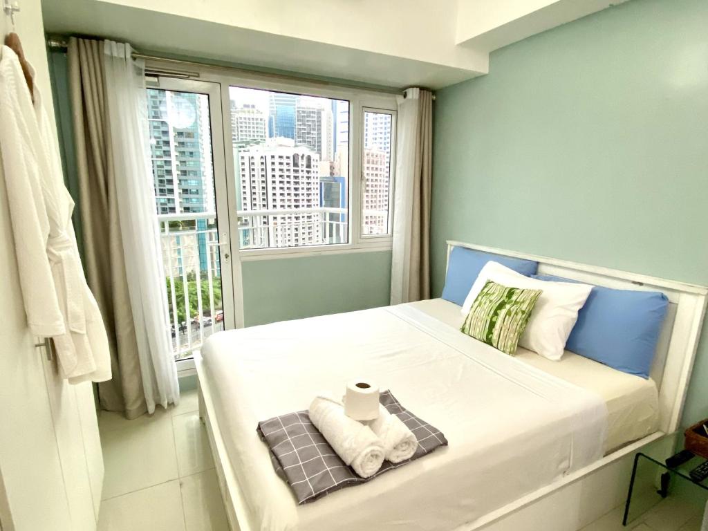 a small bedroom with a bed with a window at Cozy Studio with SM Jazz Mall "12 floor" in Manila