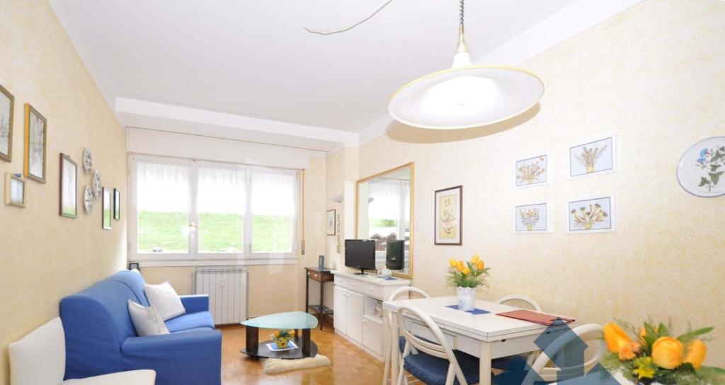 een woonkamer met een blauwe stoel en een tafel bij A casa di Ale - Foppolo in Foppolo