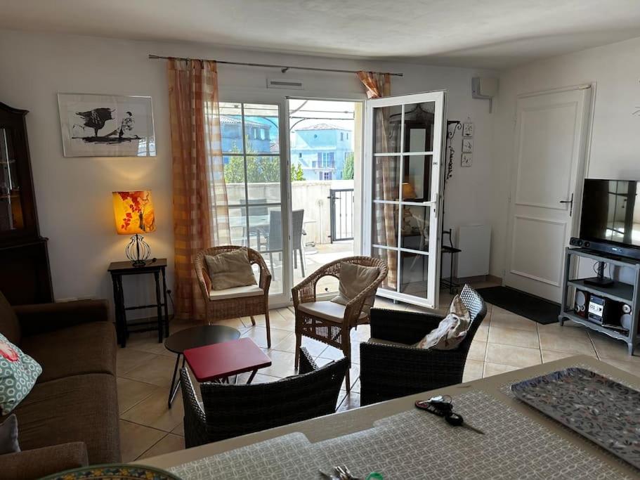 ein Wohnzimmer mit einem Sofa und Stühlen in der Unterkunft Marina 4 adultes 4 enfants piscine commune in Aigues-Mortes