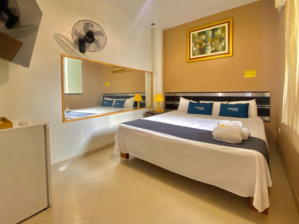 a bedroom with a large bed and a mirror at Suite Apart Miraflores in Piura