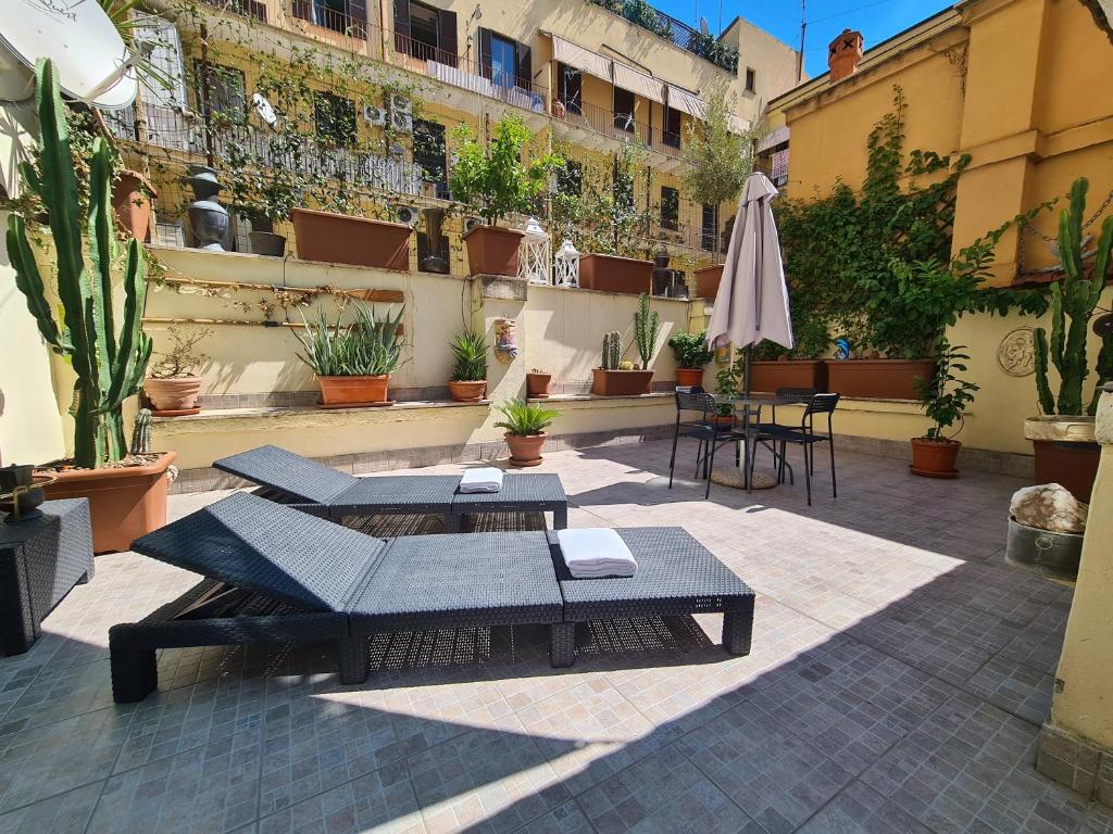 un patio con tavoli, ombrellone e piante di Rooms And Comfort a Roma