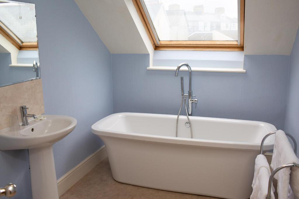 a bathroom with a bath tub and a sink at Townhouse Aberystwyth in Aberystwyth
