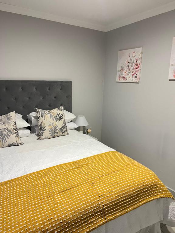 ソウェトにあるJabulani junctionのベッドルーム1室(黄色い毛布付きのベッド1台付)