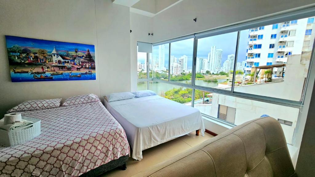 a bedroom with a bed and a large window at Torres del lago Pegasus Group Cartagena in Cartagena de Indias