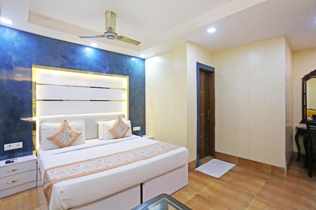 a bedroom with a large white bed and a bathroom at Frankstay by Hotel Satwah 29 Unit By Preet Palac in New Delhi