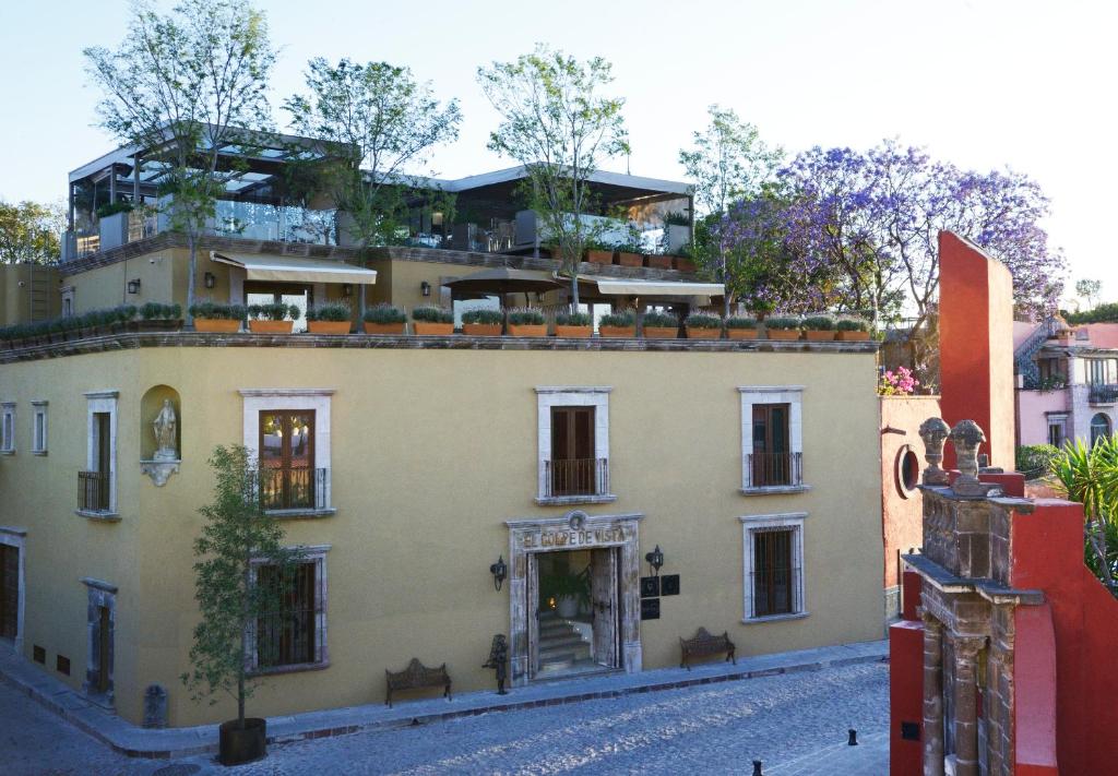 a house on top of a building on a street at El Golpe de Vista in San Miguel de Allende