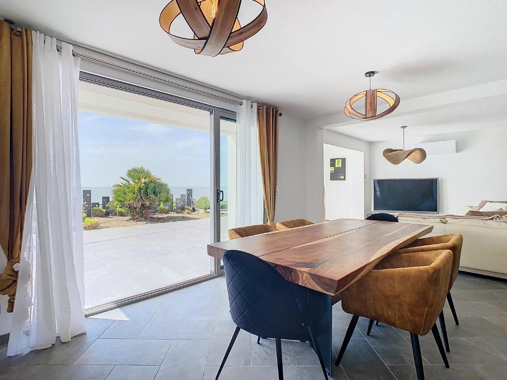 une salle à manger avec une table et des chaises en bois dans l'établissement Villa Heure Bleue, à Saint-Georges-de-Didonne