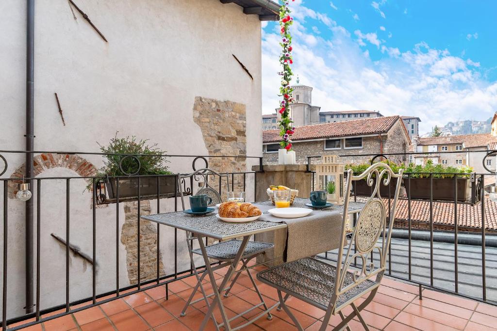 a patio with a table and chairs on a balcony at “Antica terrazza” Charme&relax in Bergamo