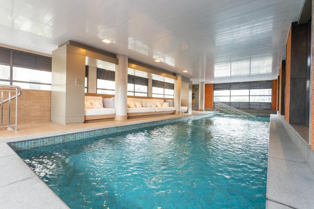 a large swimming pool in a hotel room with a pool at Charlie Itaim in Sao Paulo