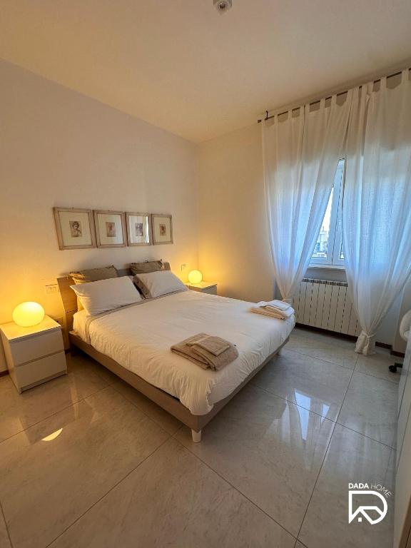 sypialnia z łóżkiem z 2 lampami i oknem w obiekcie DADA Home w mieście Bari