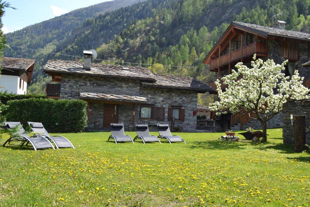 a group of chairs in a yard in front of a house at Le Petit Coeur Residence De Montagne in La Salle