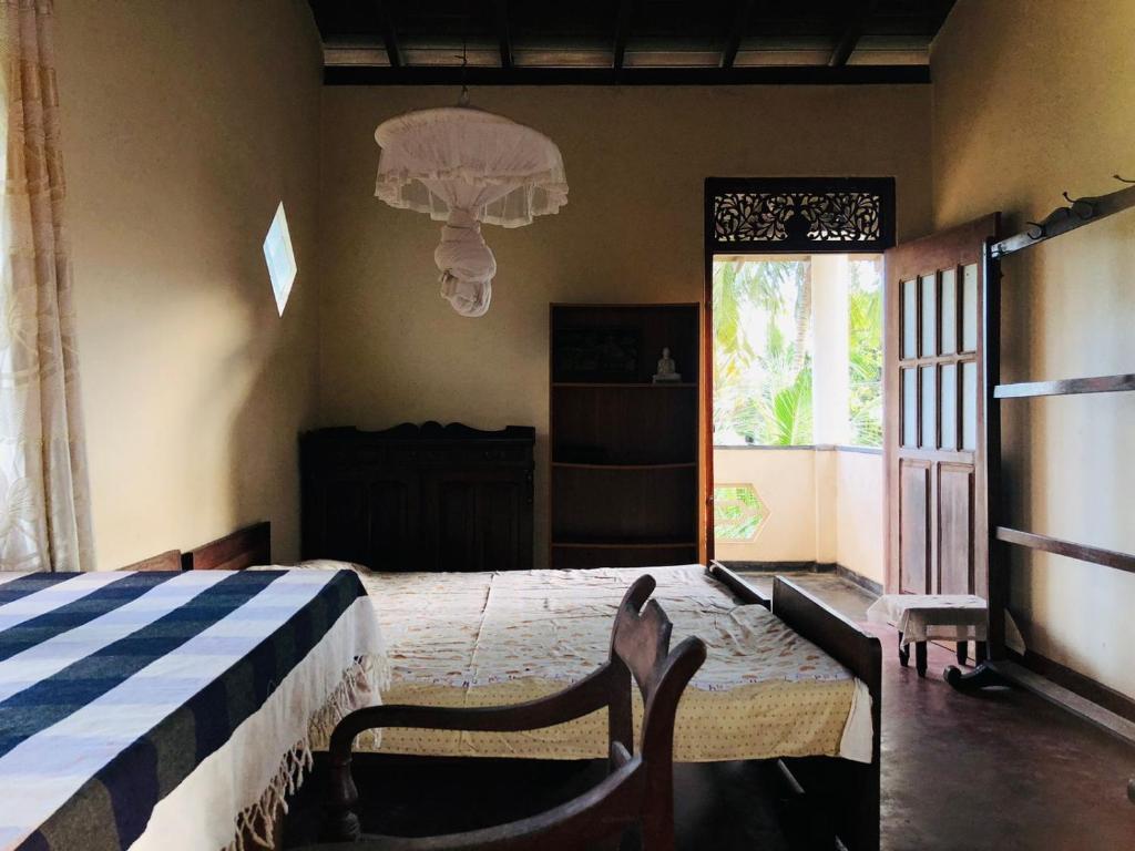 ein Schlafzimmer mit einem Bett mit einer blauen und weißen Decke in der Unterkunft Dheera niwasa villa in Talpe