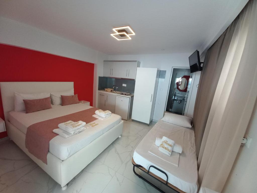 a bedroom with two beds and a red wall at House Blerina in Sarti
