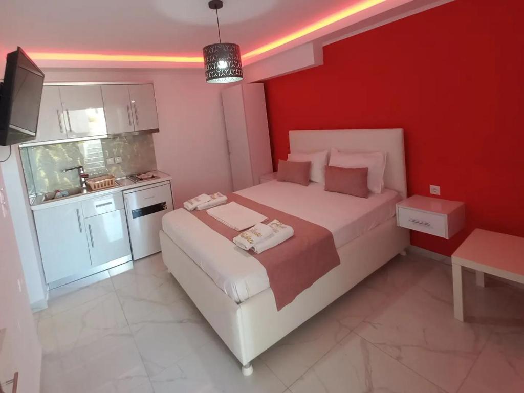 a bedroom with a large bed and a kitchen at House Blerina in Sarti