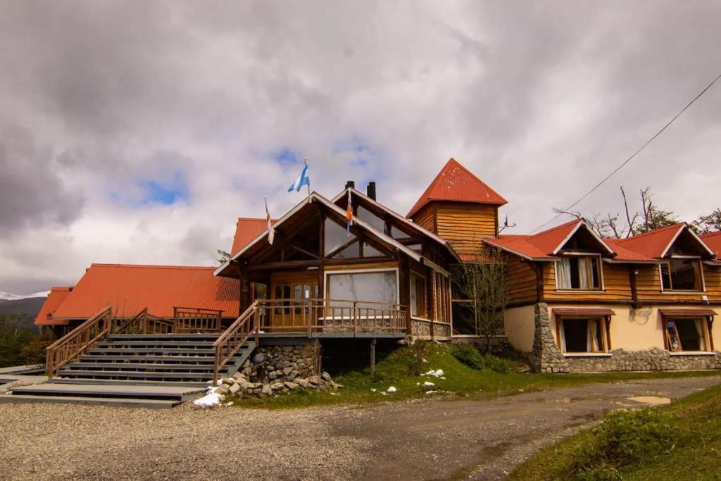 a large wooden house with a red roof at Hostería Rutalsur in Tolhuin