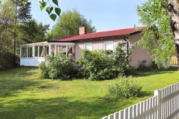 a house with a white fence in a yard at The Pink House in Halmstad