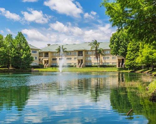un grand bâtiment avec une fontaine au milieu d'un lac dans l'établissement Be Our Silver Guest, à Orlando