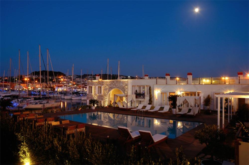 a hotel with a pool and a marina at night at Cesme Marina Konukevi in Çeşme