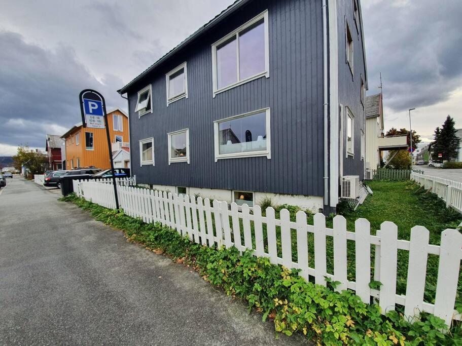 uma casa preta com uma cerca branca em Sentral leilighet, nært tog, buss, sykehus og byen em Bodø