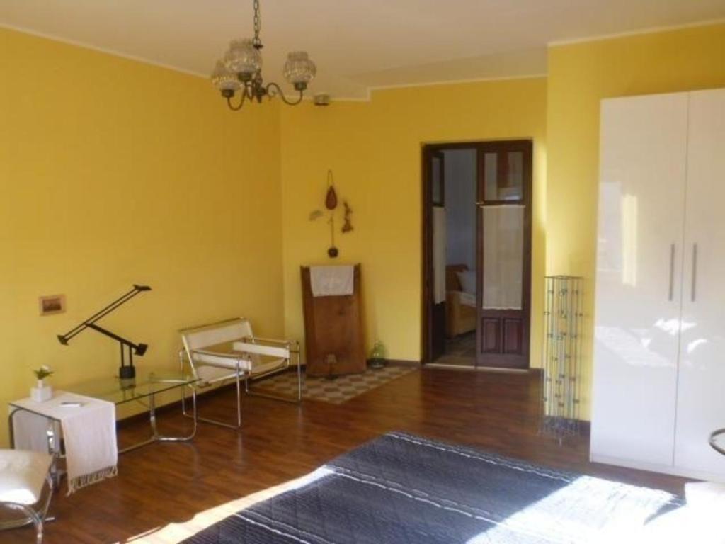 ein Wohnzimmer mit gelben Wänden und Holzböden in der Unterkunft Moderne Ferienwohnung in Rodì mit Kleiner Terrasse in Rodi