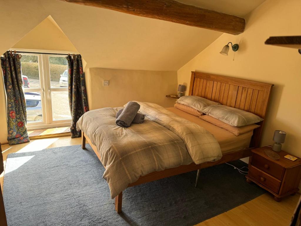 a bedroom with a bed and a window at Annie’s Cottage in Llanrhaeadr-ym-Mochnant