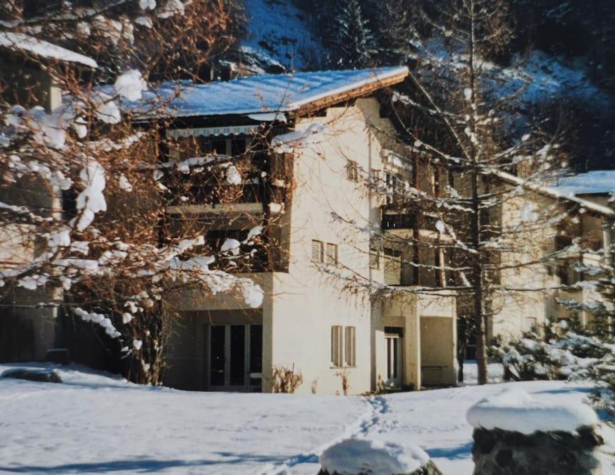 ein Haus mit Schnee auf dem Boden davor in der Unterkunft Ferienwohnung in Savognin in Savognin
