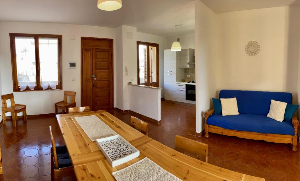 uma sala de estar com um sofá azul e uma mesa em TALAhome27 em Alghero
